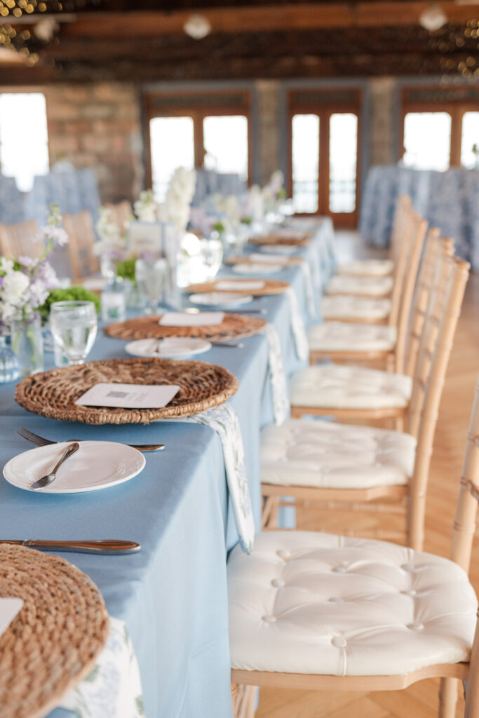 Coastal wedding tablescape with wicker chargers and blue and white decor