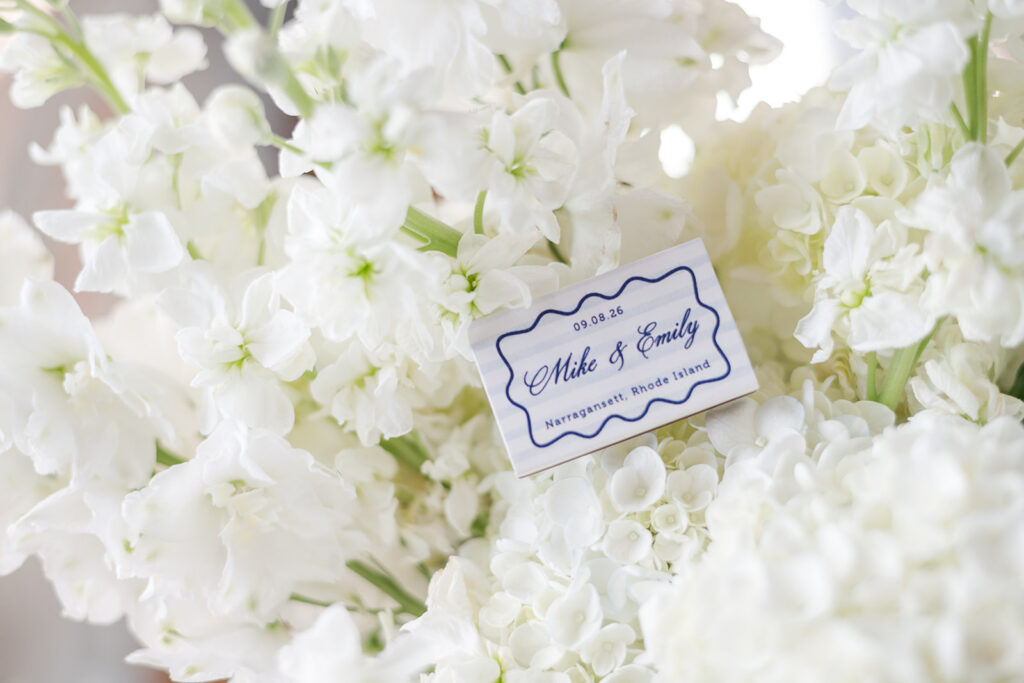 Personalized blue and white wedding matchbook surrounded by white flowers