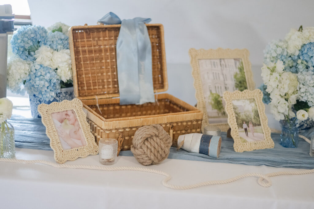Coastal wedding welcome table with wicker basket and frames